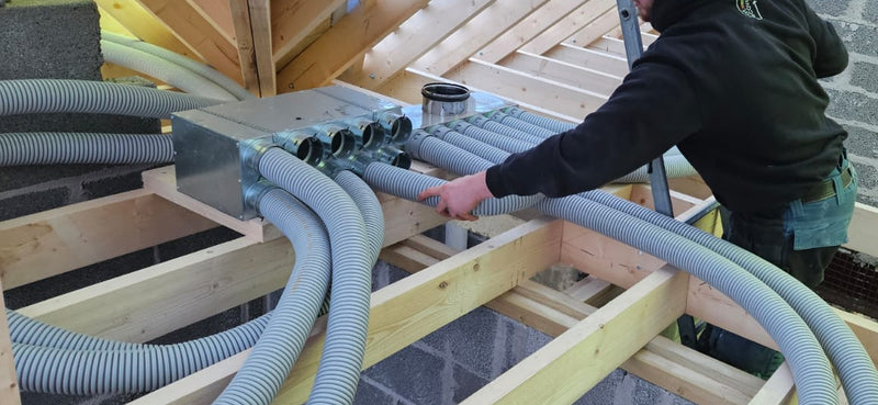 Person working on a construction project with wooden beams and pipes.
